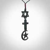 This pendant is a series of religious symbols carved in one piece of black jade. The top is a star of david, next is a christian cross and at the bottom is the crescent of islam. It is suspended on a fine, plaited black cord which is length adjustable.